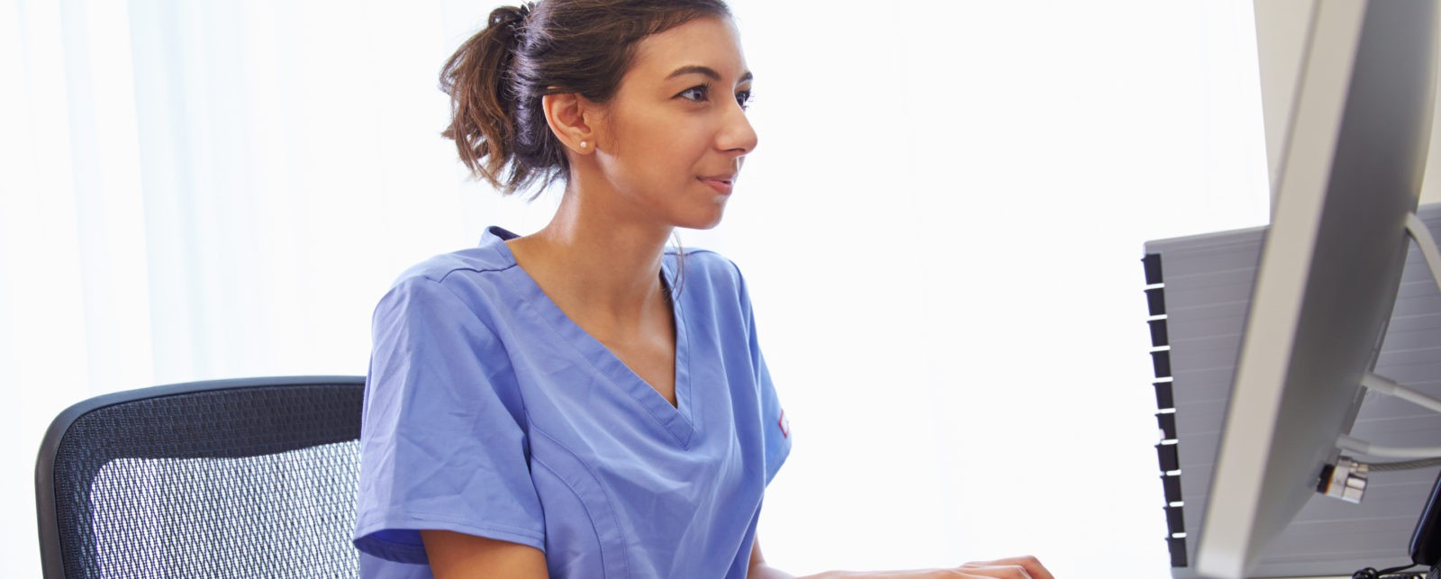 Image of woman working on a Physical Therapy EMR